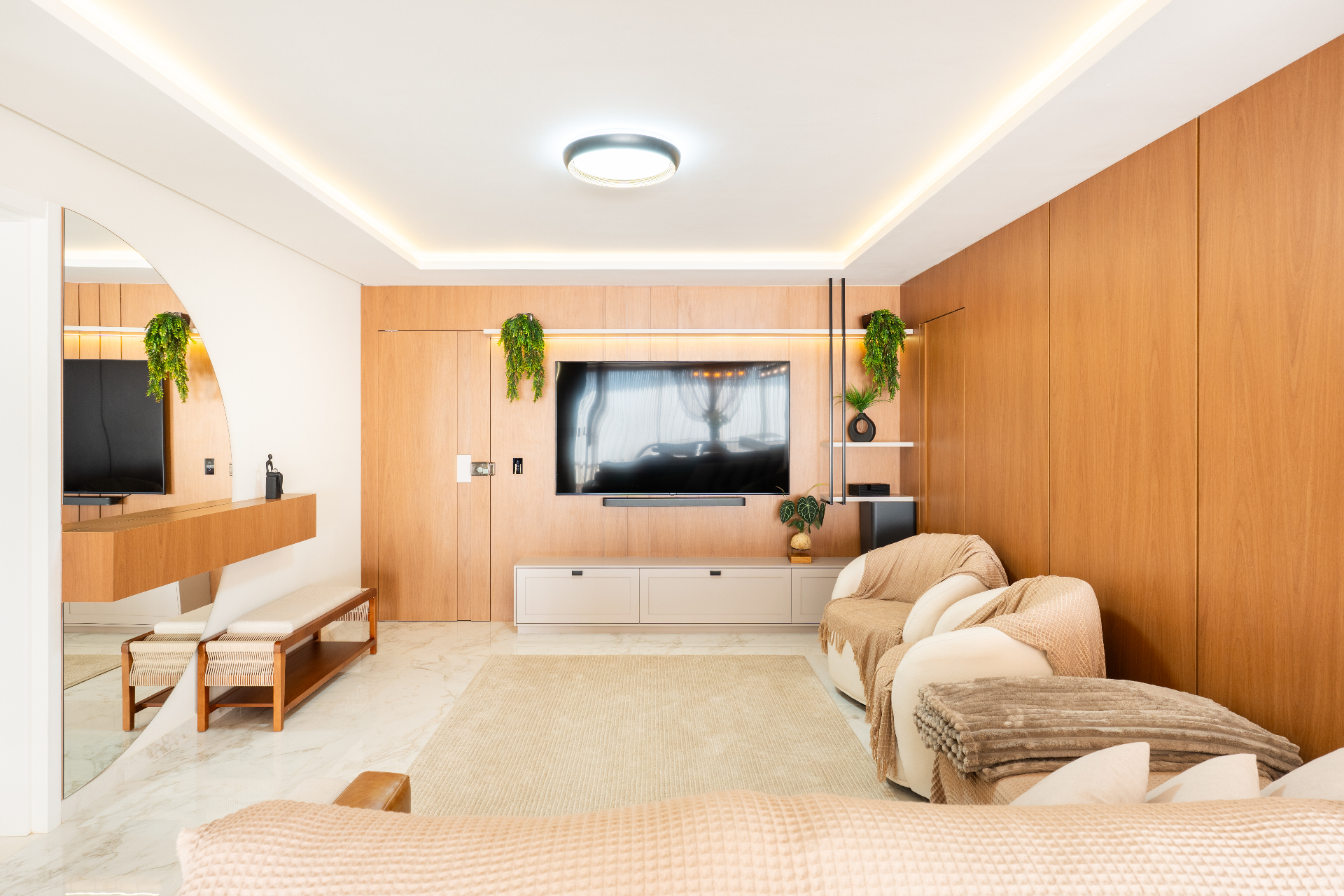 Living com painel de TV em madeira e espelho arco
