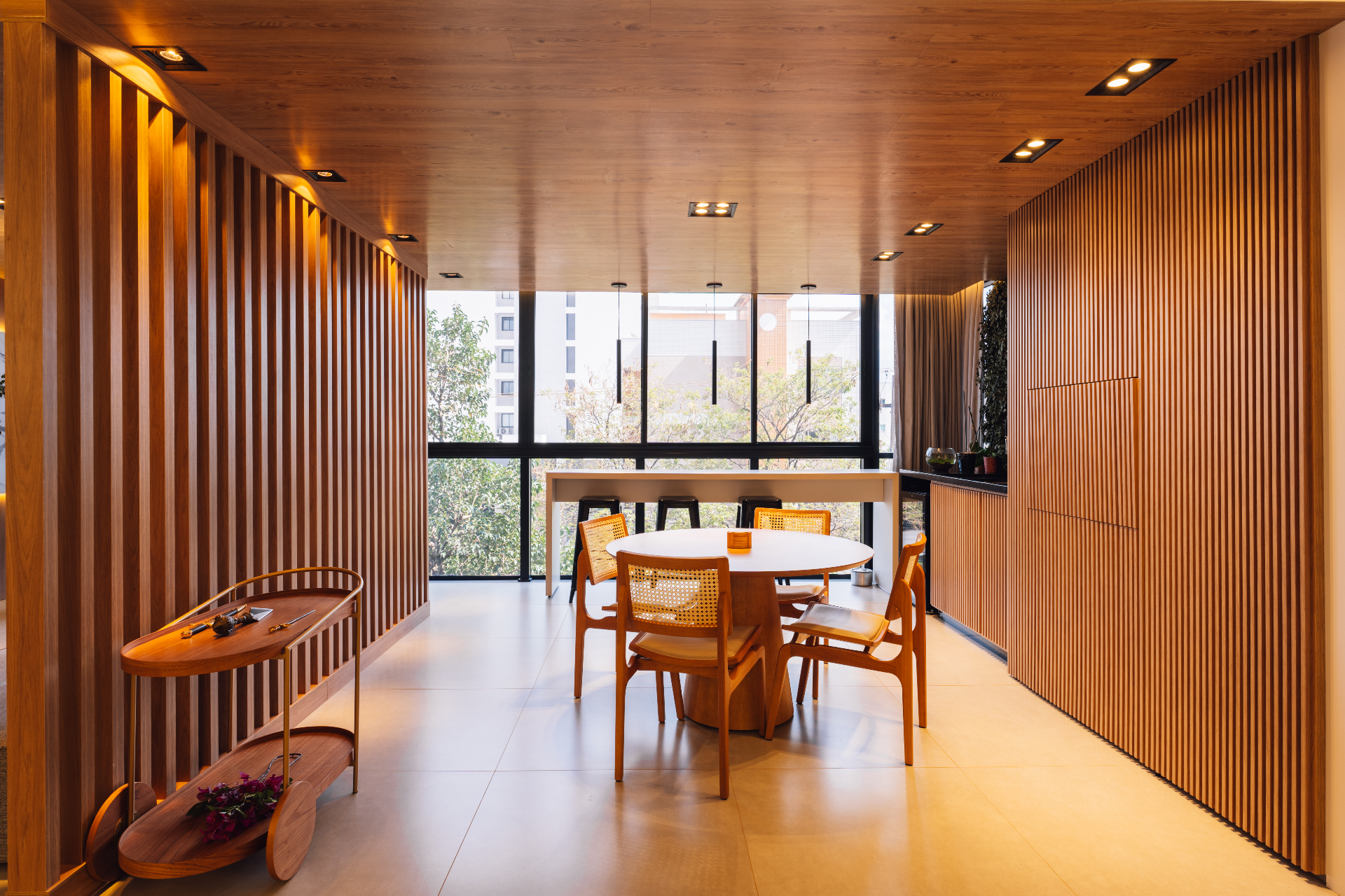 Sala de jantar com ripado em madeira e mesa redonda