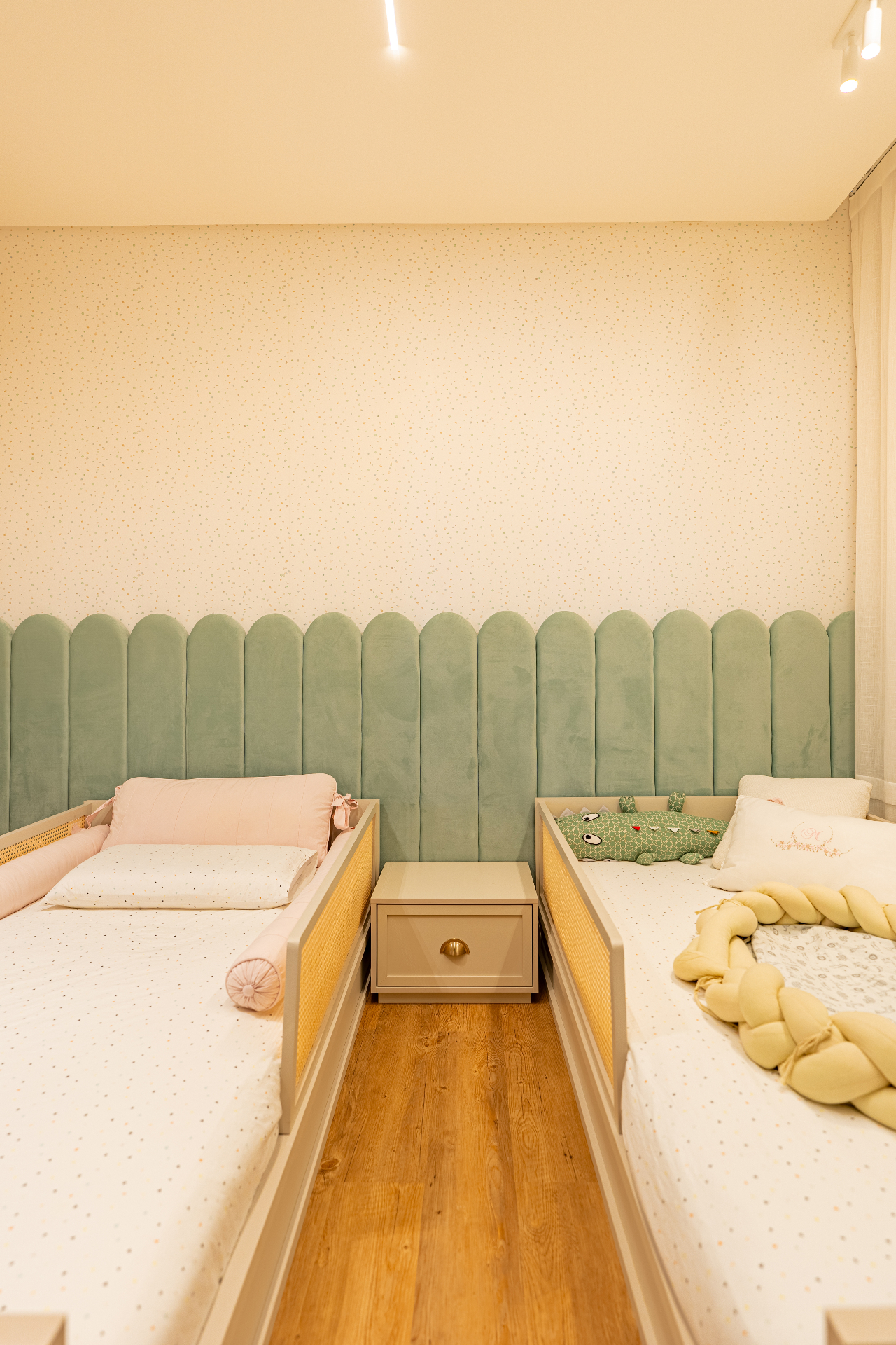 Quarto infantil com camas gêmeas e cabeceira verde